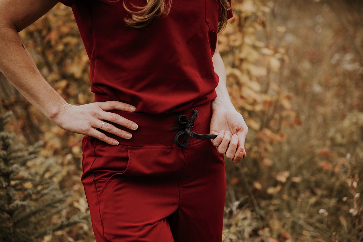 Drawstring waistband and fabric drape on a merlot KOA scrub set