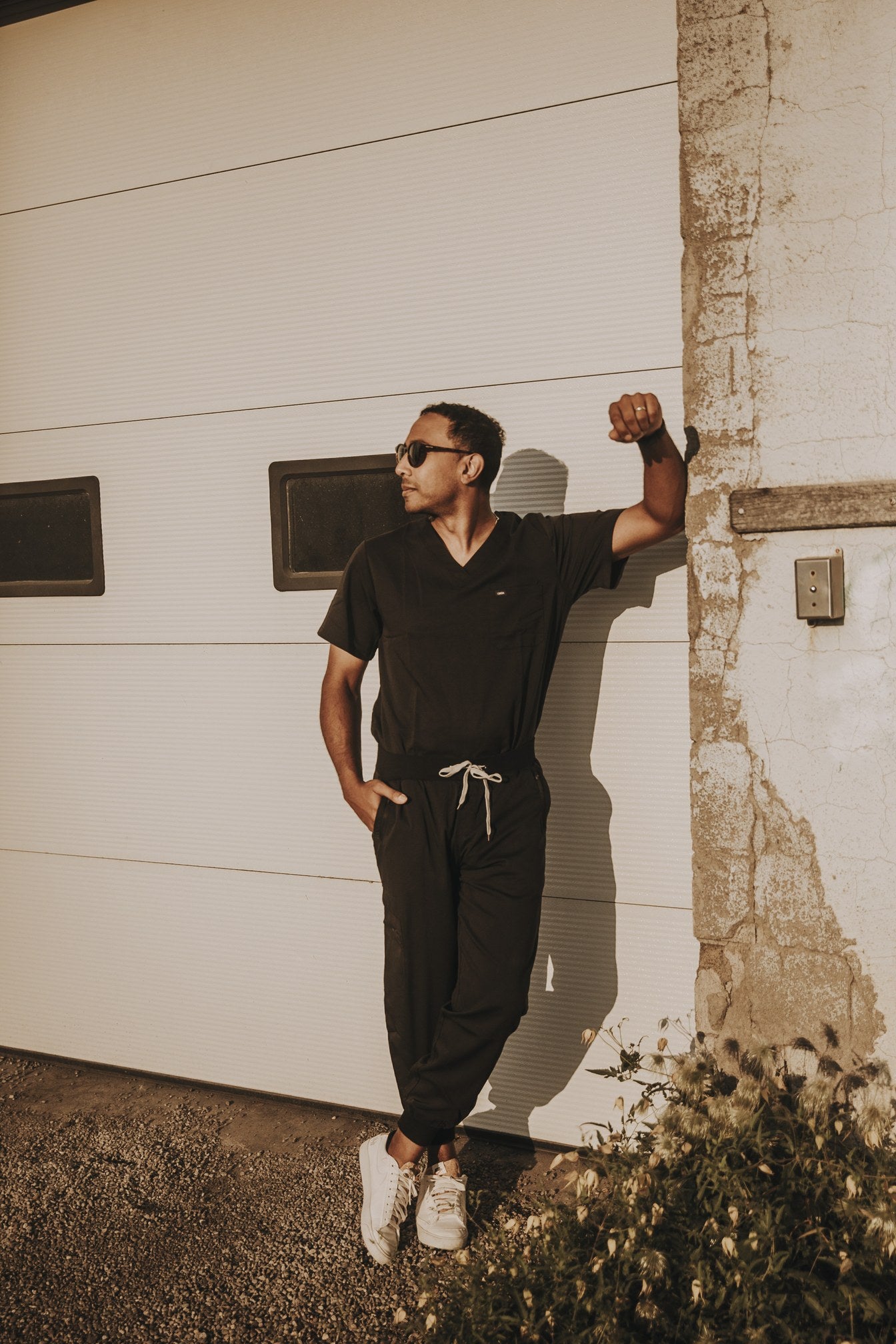 Man in a black KOA scrub set - V-neck top and joggers with contrast drawstring