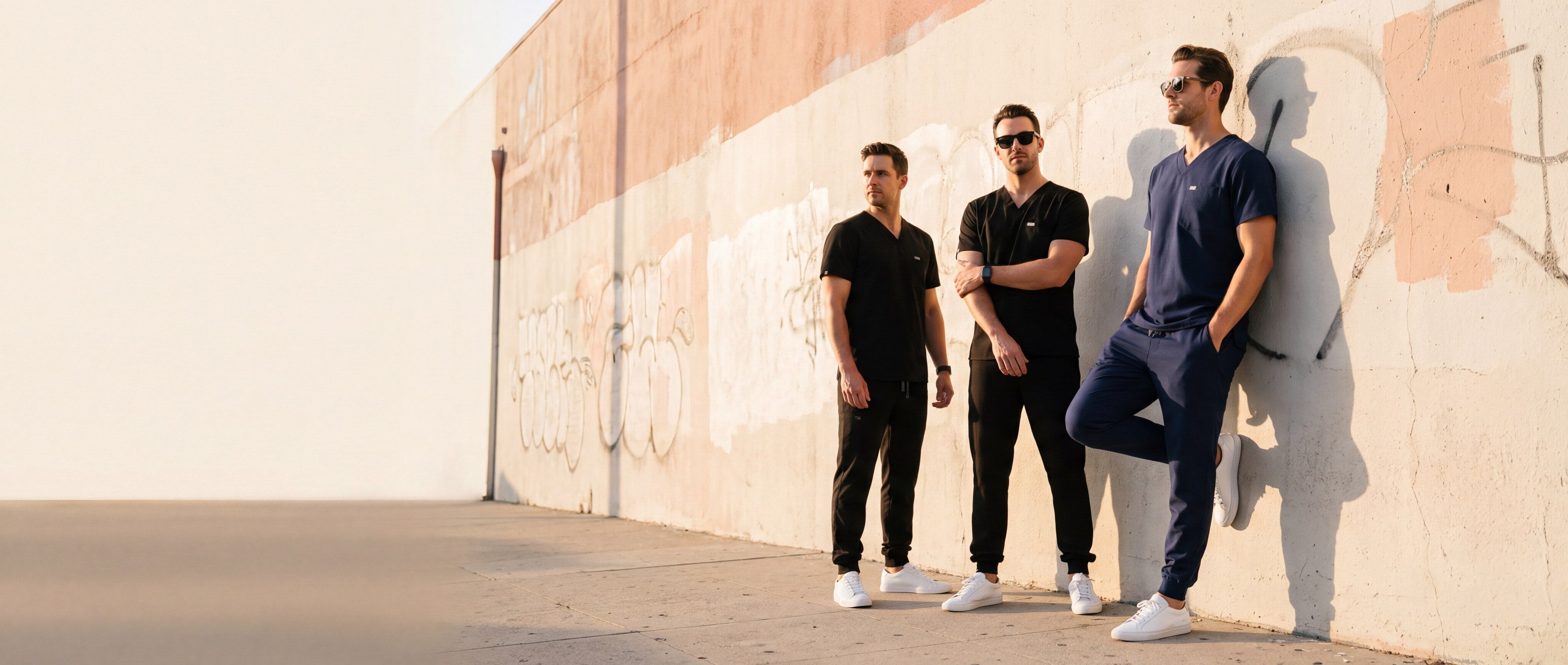 Men's KOA scrubs — three clinicians in navy and black