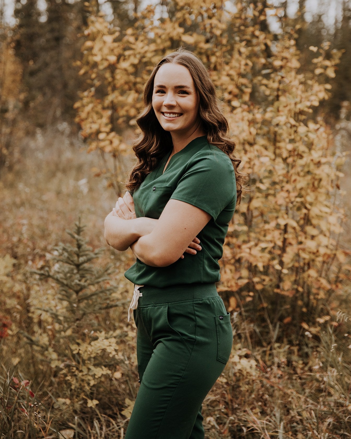 Forest green KOA high rise scrub joggers and matching top, worn outdoors