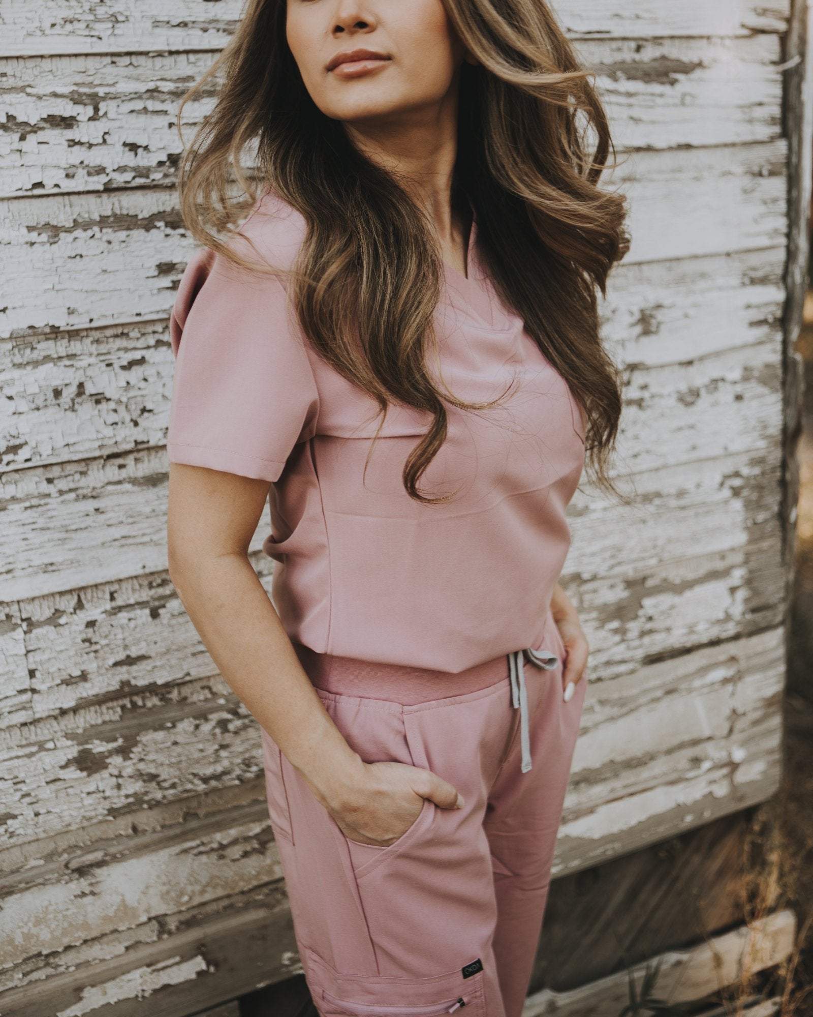 Full-length fit of the blush pink KOA scrub set